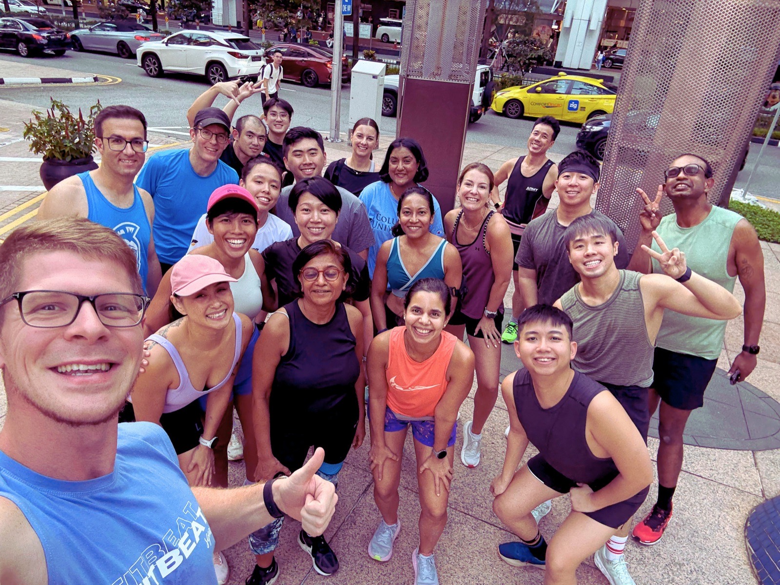 A large FitBeat group photographed together on the street after a run social in Singapore