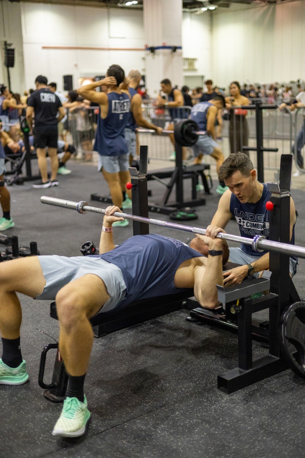 A FitBeat coach spotting a lifter at a brand fitness activation in Singapore