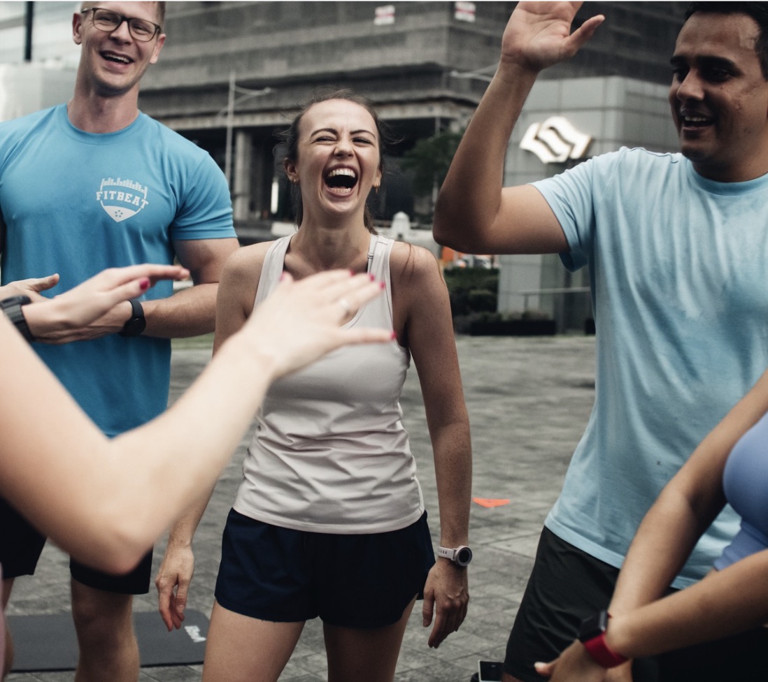 A FitBeat coach talking with clients after an outdoor session
