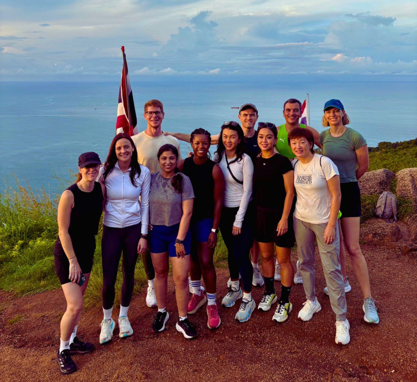 A FitBeat retreat group photographed on a hilltop overlooking the sea